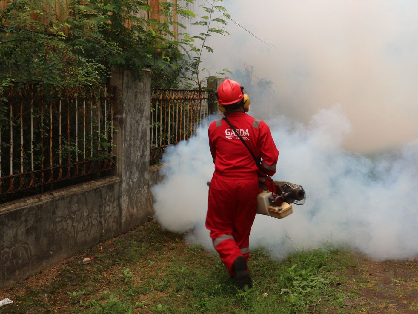 Pest control specialist treating an outdoor yard