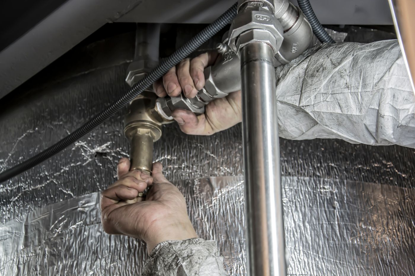 Plumber using tools to install pipe fittings